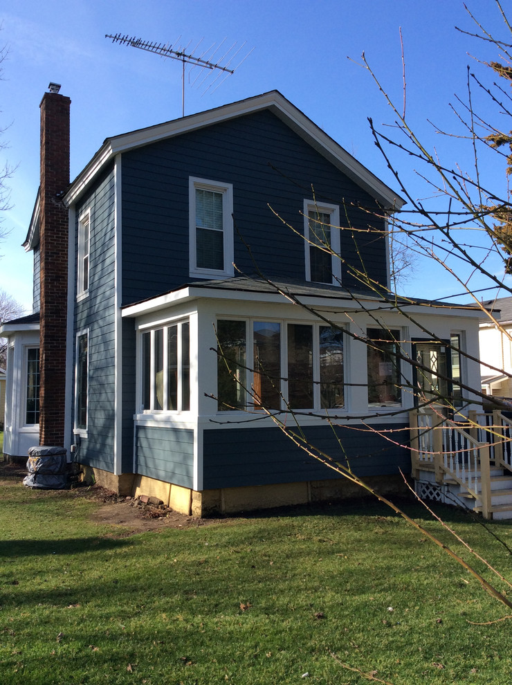 Foto de fachada de casa azul clásica de tamaño medio de dos plantas con revestimiento de aglomerado de cemento, tejado de teja de madera y tejado a dos aguas