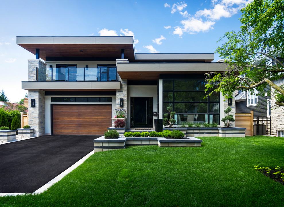 Cette image montre une grande façade de maison blanche design en stuc à un étage avec un toit plat.