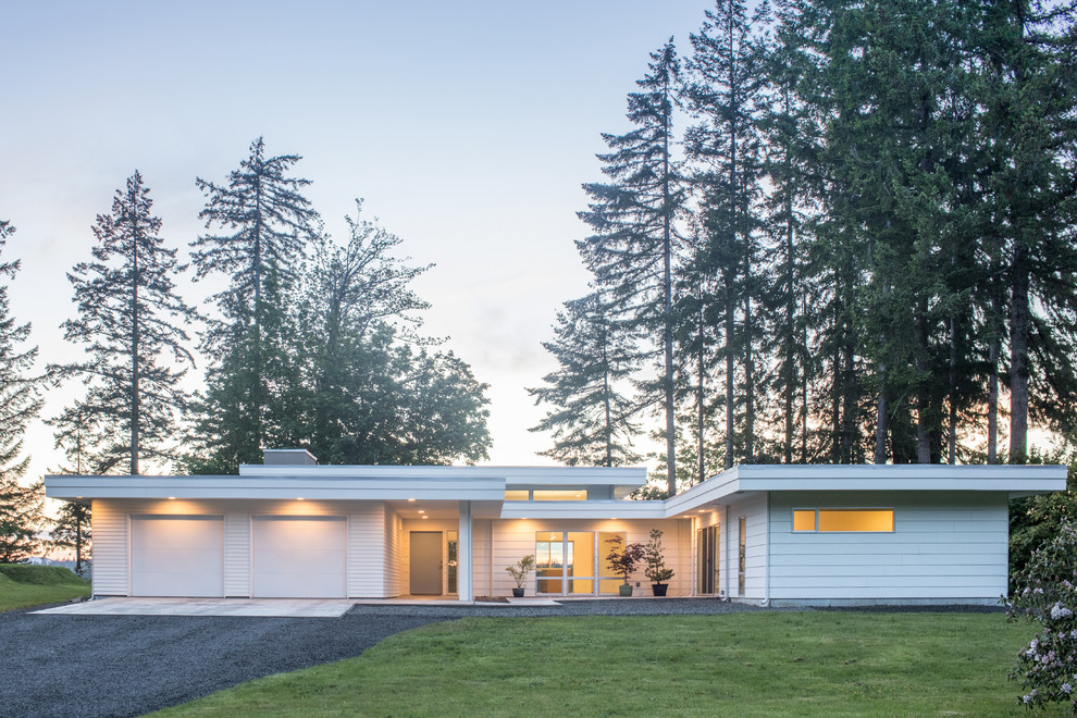 Imagen de fachada de casa blanca moderna de tamaño medio de una planta con revestimiento de madera, tejado plano y tejado de metal