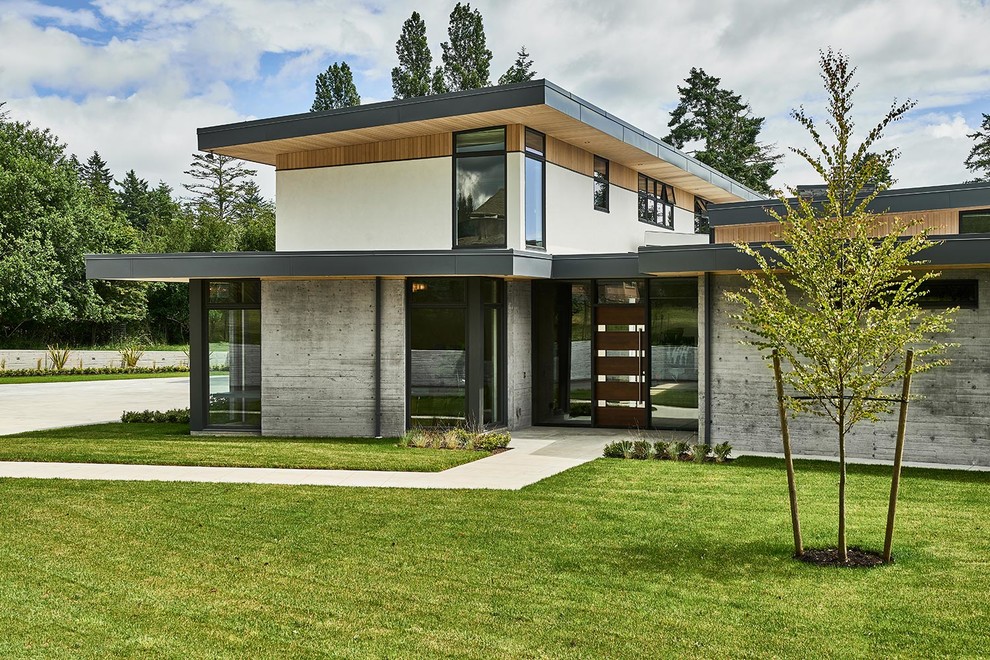 Идея дизайна: большой, двухэтажный, серый частный загородный дом в стиле модернизм с облицовкой из бетона, плоской крышей и крышей из смешанных материалов