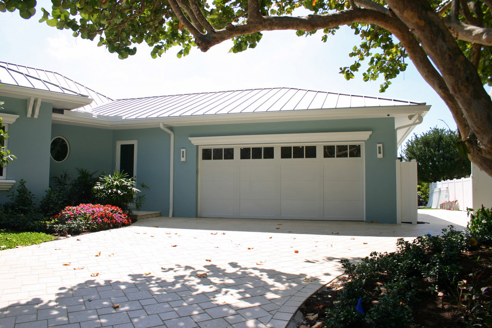 Imagen de fachada de casa azul costera de tamaño medio de una planta con revestimiento de estuco, tejado a cuatro aguas y tejado de metal