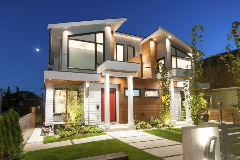 Modelo de fachada de casa multicolor contemporánea de tamaño medio de dos plantas con revestimientos combinados, tejado a dos aguas y techo verde
