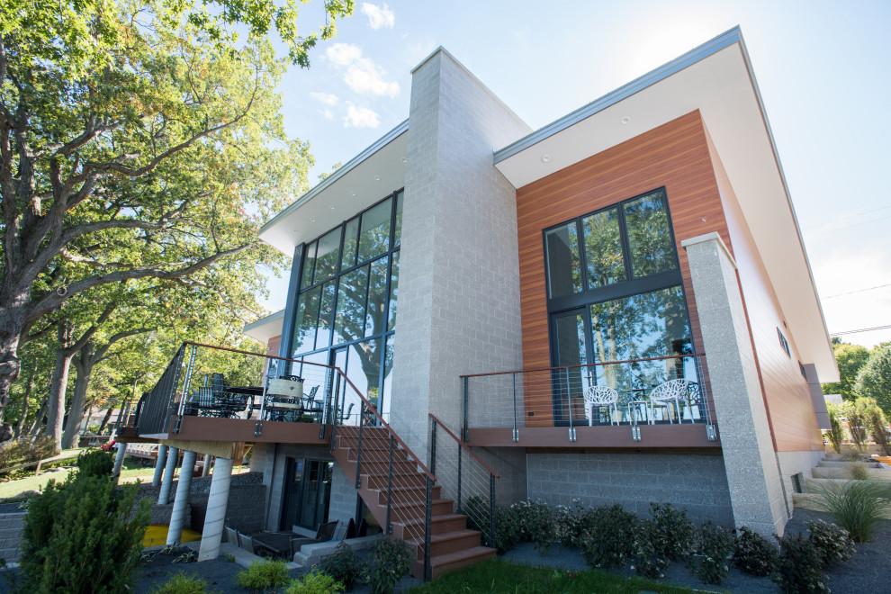 Großes, Zweistöckiges Modernes Einfamilienhaus mit Betonfassade, brauner Fassadenfarbe, Pultdach, Blechdach und grauem Dach in Grand Rapids