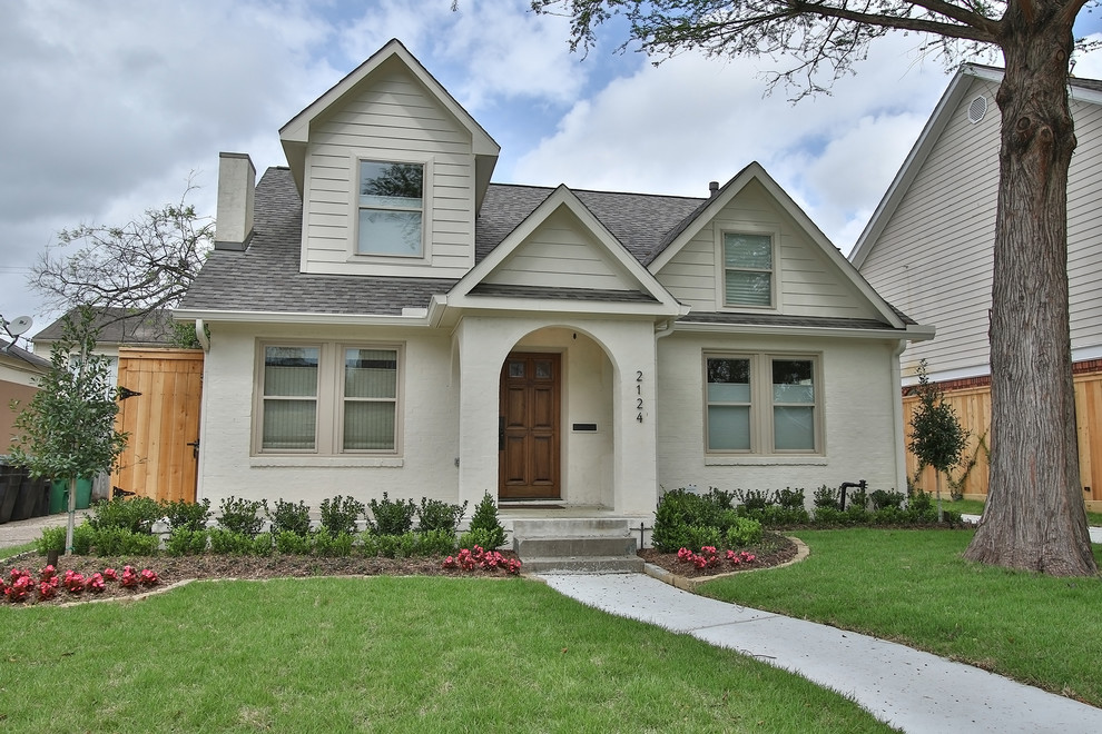 Example of a large arts and crafts beige two-story brick gable roof design in Houston