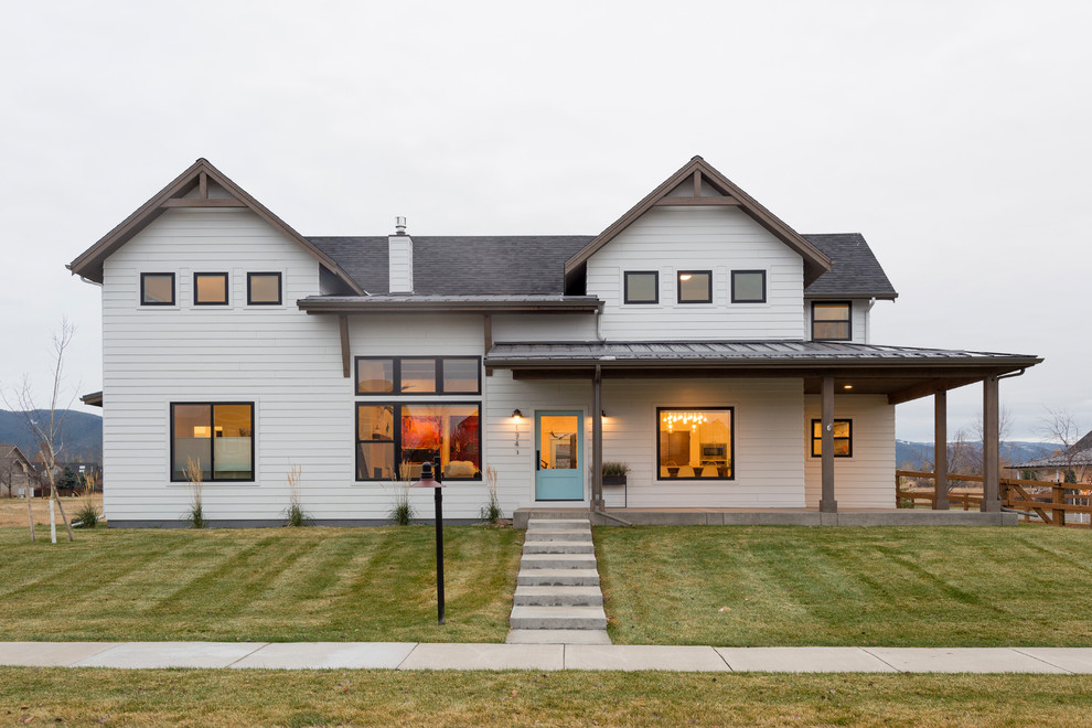 Zweistöckiges Country Einfamilienhaus mit weißer Fassadenfarbe, Satteldach und Schindeldach in Sonstige