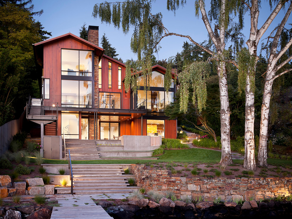 Cette photo montre une grande façade de maison marron tendance en bois à deux étages et plus avec un toit à deux pans.