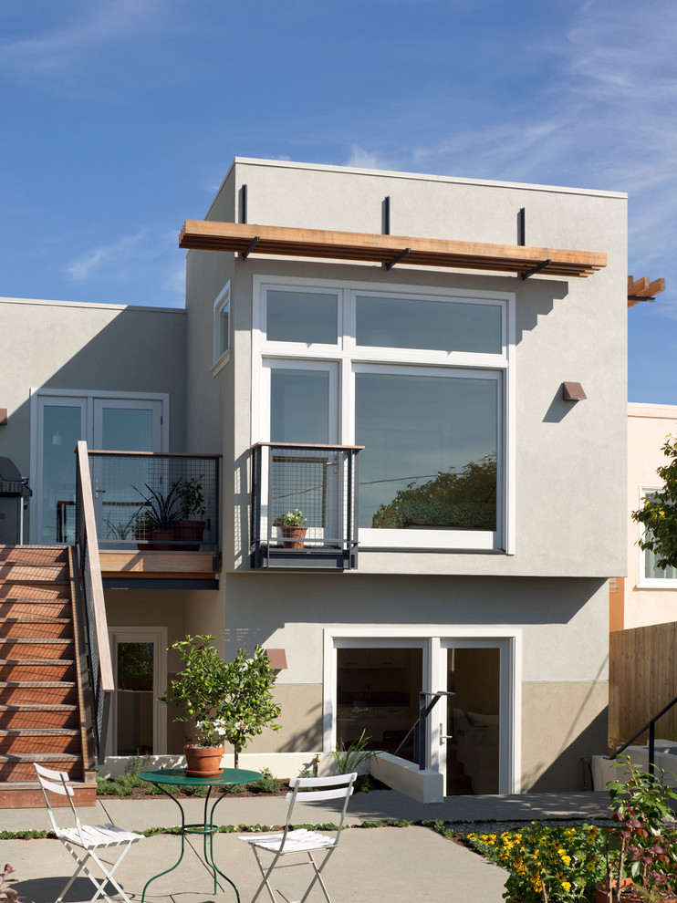 Aménagement d'une façade de maison grise bord de mer à un étage.