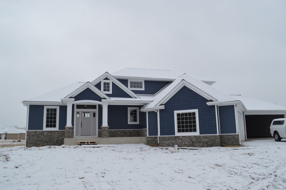 Diseño de fachada de casa azul de estilo americano grande de dos plantas con revestimientos combinados, tejado a cuatro aguas y tejado de teja de madera