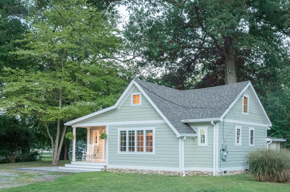 Idée de décoration pour une petite façade de maison verte marine en panneau de béton fibré de plain-pied avec un toit à deux pans et un toit en shingle.