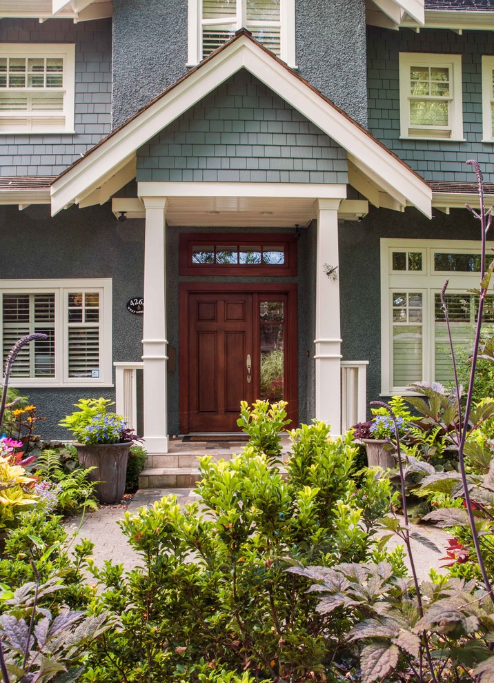 Photo of a gey traditional render house exterior in Vancouver.