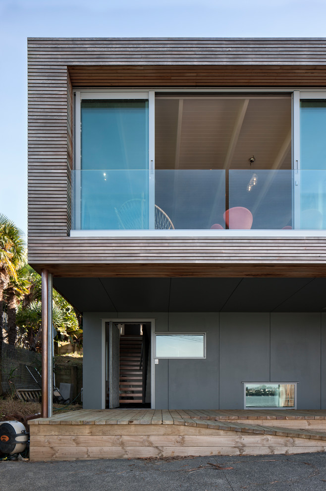 Aménagement d'une grande façade de maison multicolore contemporaine à un étage avec un revêtement mixte et un toit plat.