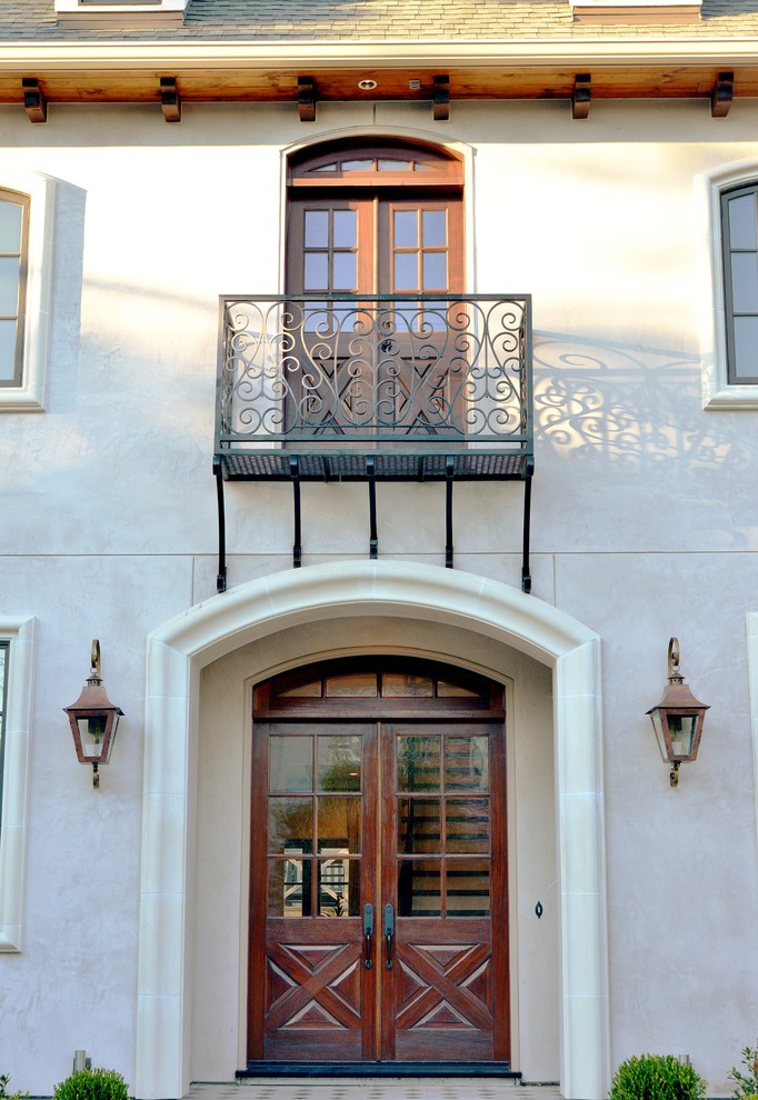 Immagine della facciata di una casa grande beige mediterranea a due piani con rivestimento in stucco e tetto a padiglione