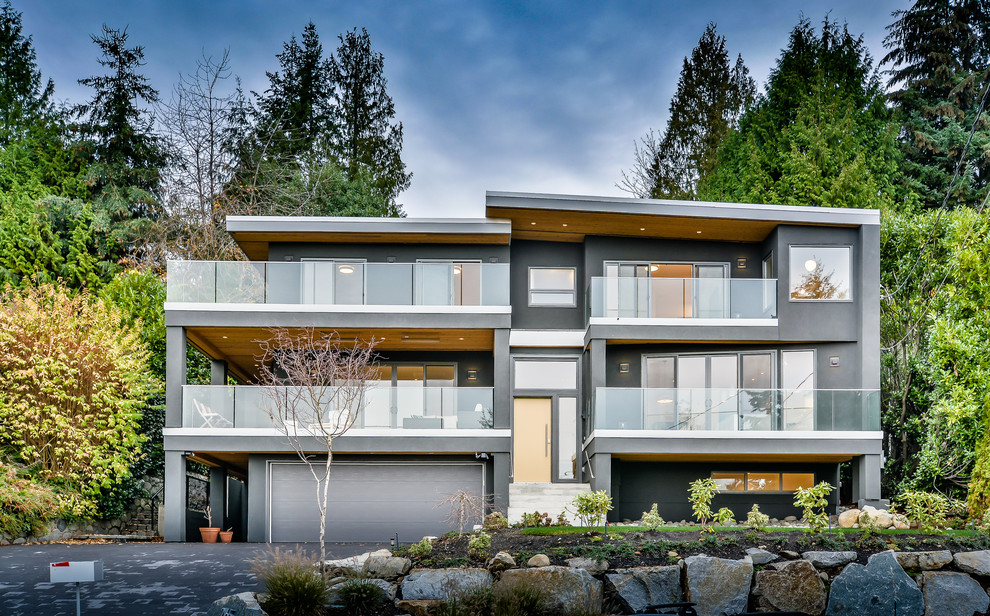 Photo of a gey modern render house exterior in Vancouver with three floors and a flat roof.