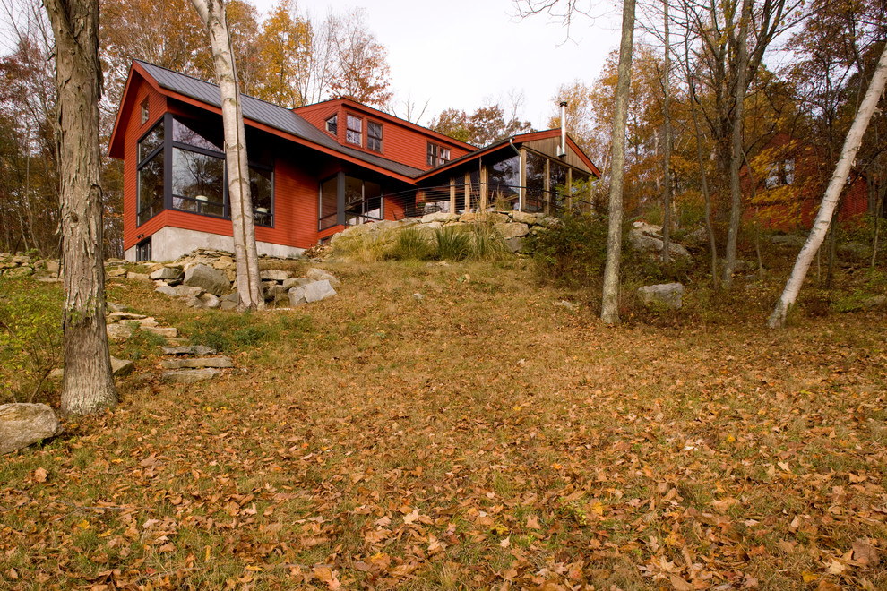 Diseño de fachada de casa roja rural con tejado a dos aguas y tejado de metal