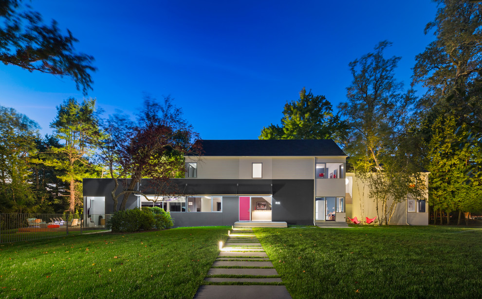 На фото: двухэтажный, разноцветный частный загородный дом в современном стиле с двускатной крышей с