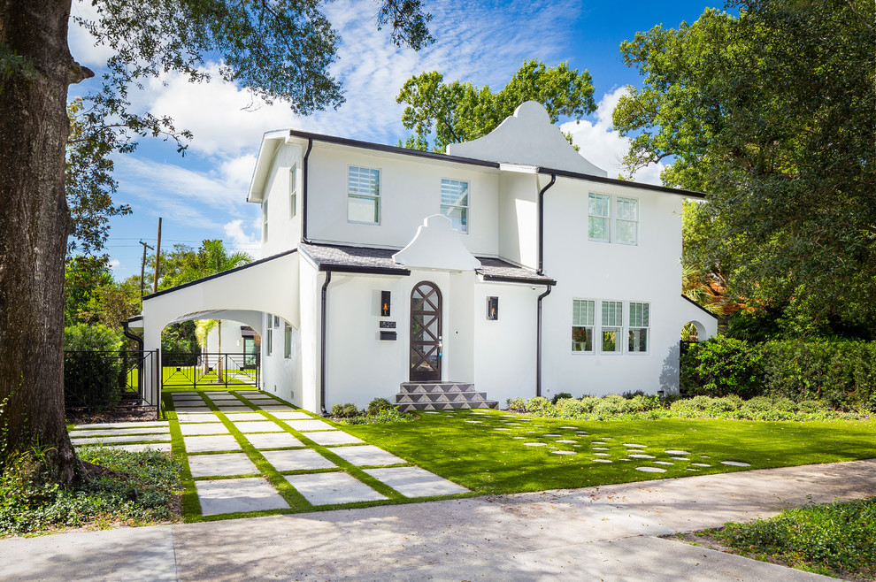 Cette photo montre une façade de maison blanche chic en stuc à un étage.