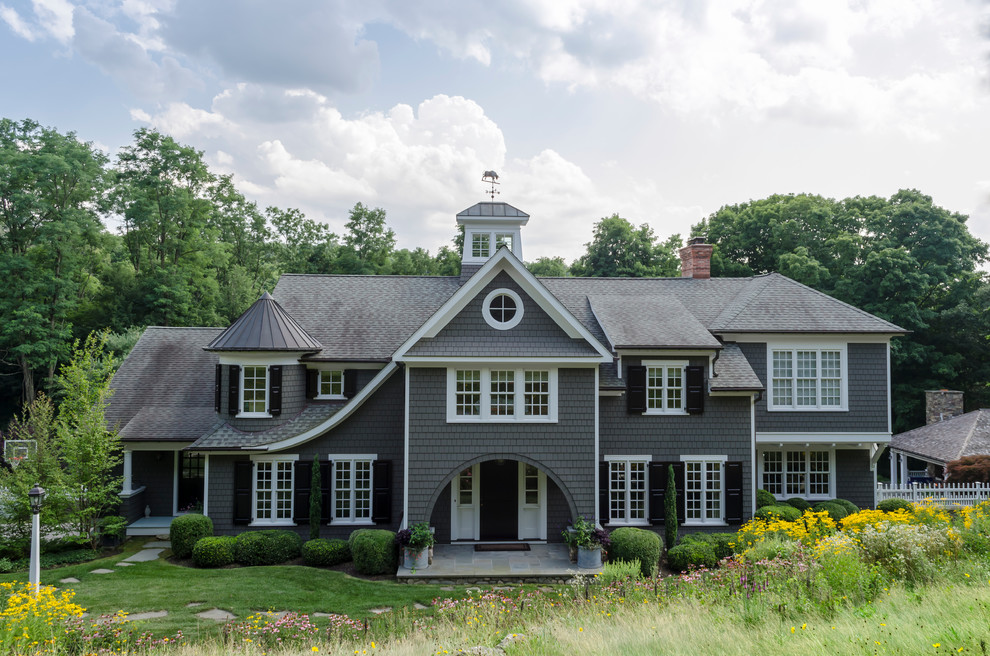 Стильный дизайн: огромный, трехэтажный, деревянный, серый дом в викторианском стиле с двускатной крышей - последний тренд