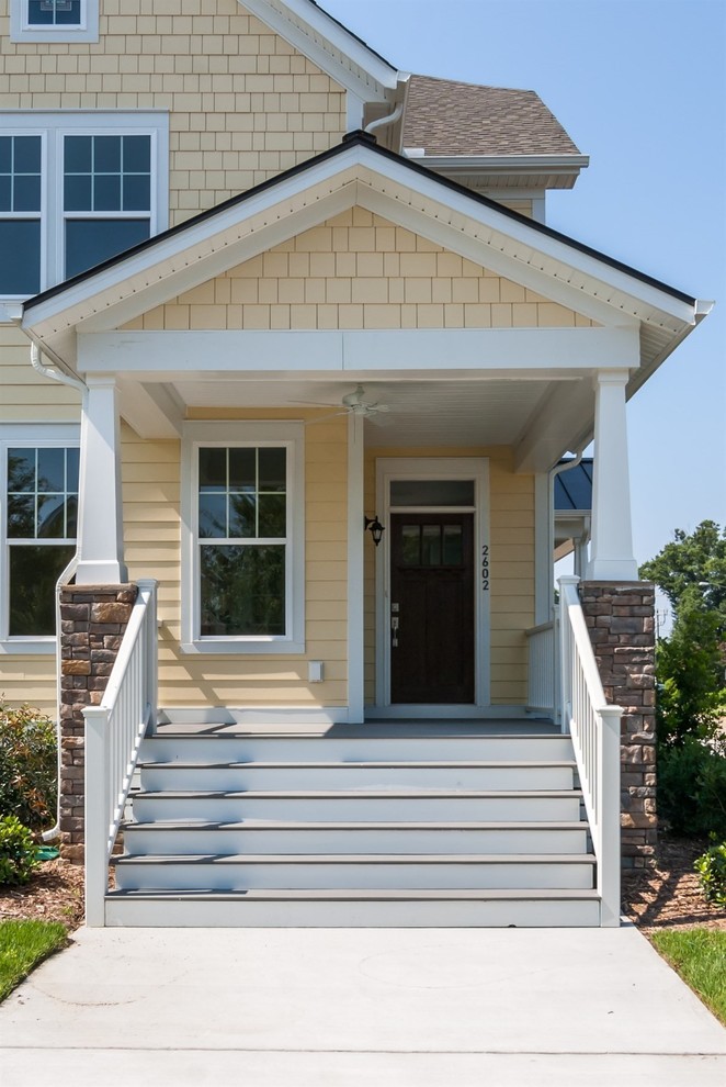 Стильный дизайн: большой, двухэтажный, деревянный, желтый дом в классическом стиле с двускатной крышей - последний тренд