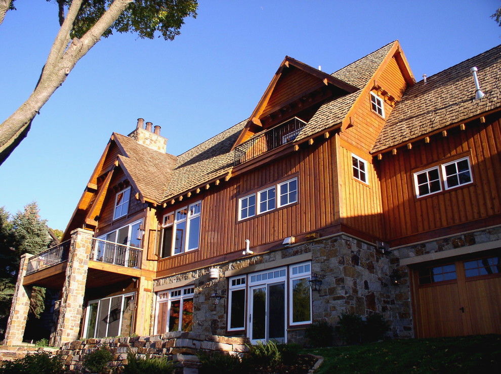 Aménagement d'une grande façade de maison marron montagne en bois à un étage avec un toit à deux pans.
