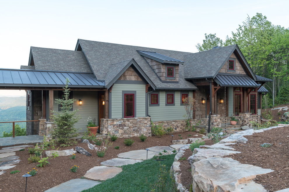 Exemple d'une façade de maison verte montagne en panneau de béton fibré de taille moyenne et à un étage avec un toit à deux pans.