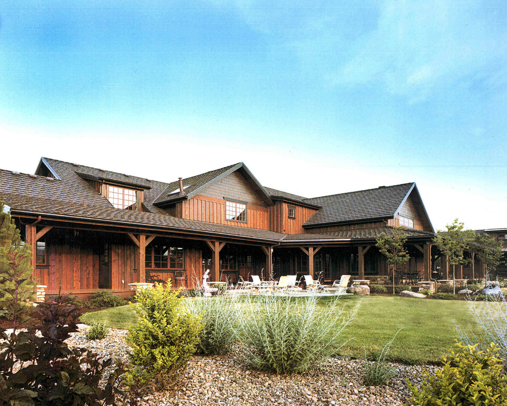 Modelo de fachada de casa marrón de estilo americano grande de dos plantas con revestimientos combinados, tejado a dos aguas y tejado de teja de madera