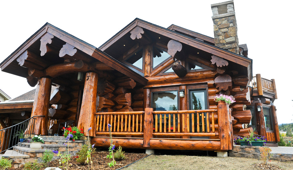 Стильный дизайн: коричневый, большой частный загородный дом в стиле рустика с разными уровнями, комбинированной облицовкой, двускатной крышей и крышей из гибкой черепицы - последний тренд