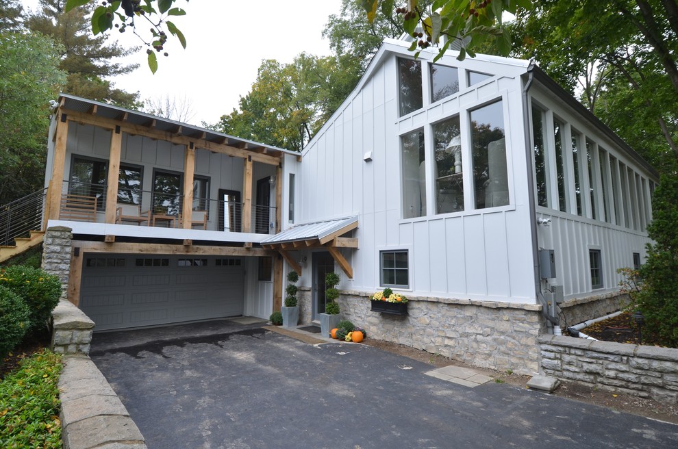 Foto della facciata di una casa grande grigia contemporanea a due piani con rivestimento in legno e tetto a capanna
