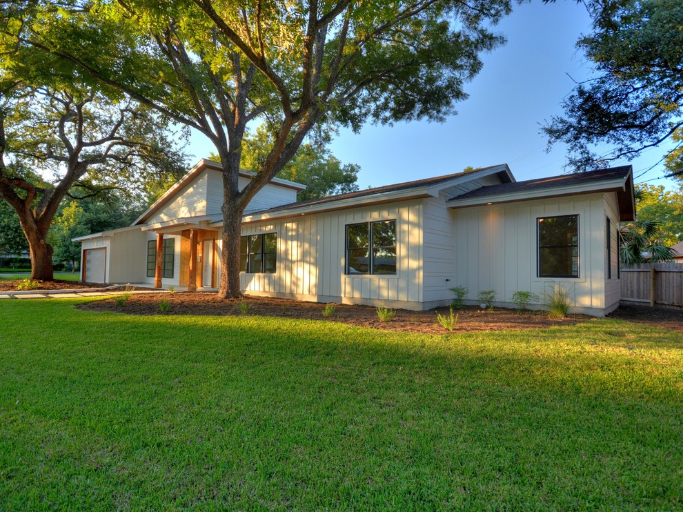 Example of a 1950s white one-story wood exterior home design in Austin with a shed roof