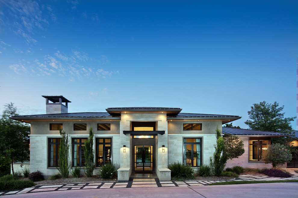 Einstöckiges Modernes Haus mit Steinfassade, grauer Fassadenfarbe und Walmdach in Austin