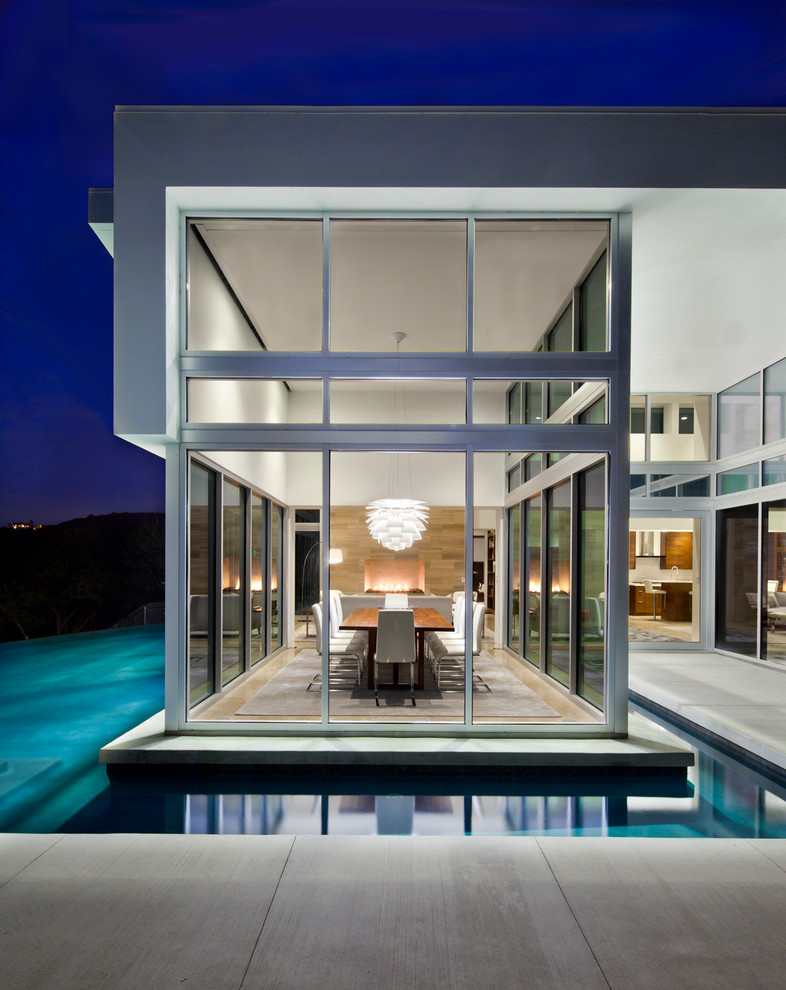 Einstöckiges Modernes Haus mit Glasfassade, weißer Fassadenfarbe und Flachdach in Austin