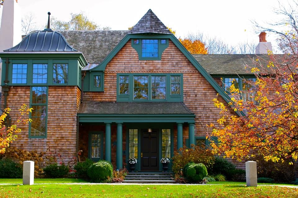 Exemple d'une très grande façade de maison verte craftsman en bois à deux étages et plus avec un toit à croupette.