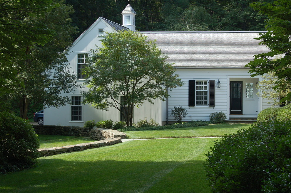 Modelo de fachada blanca tradicional extra grande de dos plantas con revestimiento de vinilo y tejado a dos aguas