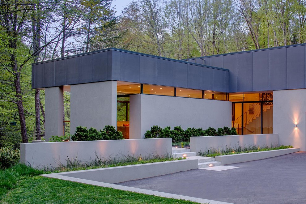 Photo of a gey modern concrete house exterior in New York with a flat roof.