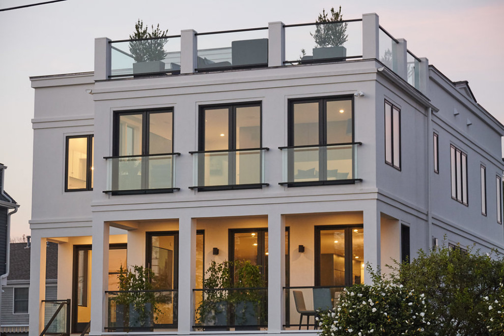 Diseño de fachada de casa blanca minimalista de tamaño medio de tres plantas con revestimiento de estuco y tejado plano