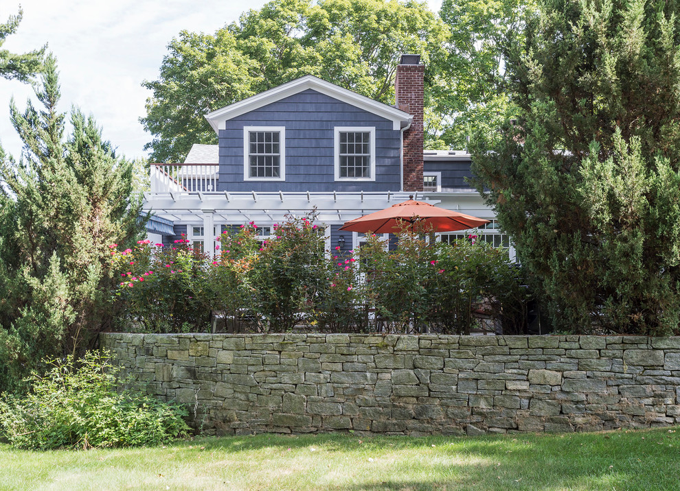 Immagine della facciata di una casa grande blu country a due piani con tetto a capanna