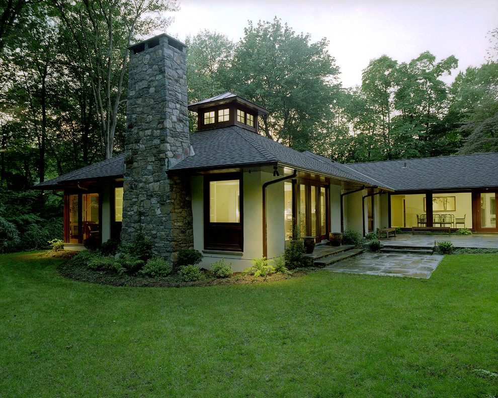 Exemple d'une façade de maison blanche tendance en stuc de taille moyenne et de plain-pied avec un toit à quatre pans.