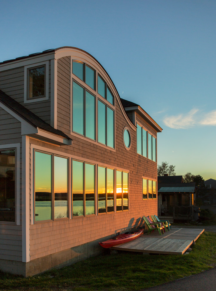 На фото: двухэтажный, деревянный, серый дом в морском стиле с