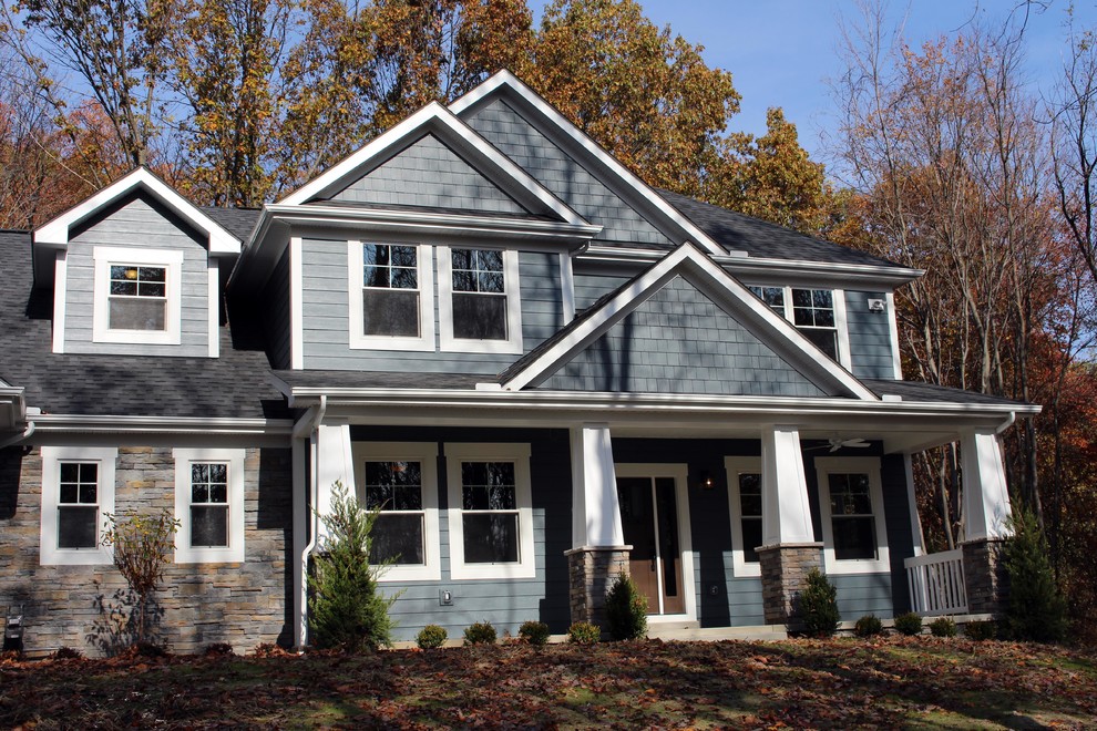 Example of a large arts and crafts blue two-story concrete fiberboard exterior home design in Other with a hip roof