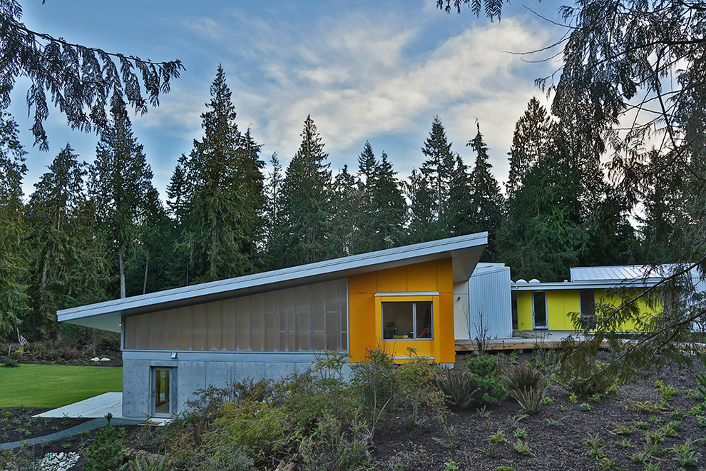 Ejemplo de fachada de casa multicolor industrial de dos plantas con revestimientos combinados, tejado de un solo tendido y tejado de metal