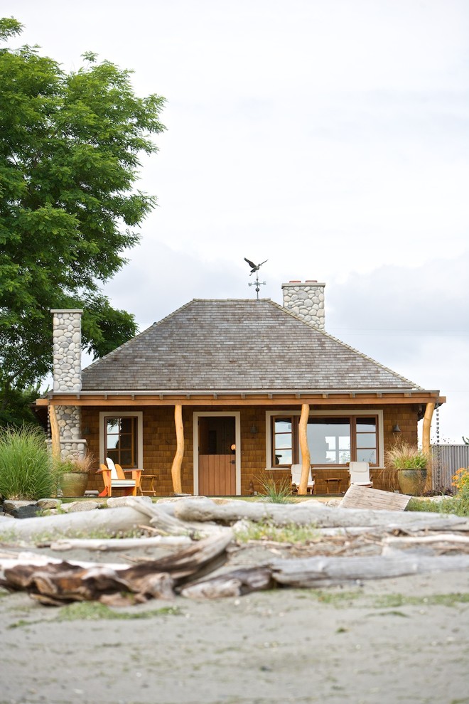 Foto della facciata di una casa marrone stile marinaro di medie dimensioni con rivestimento in legno e tetto a padiglione