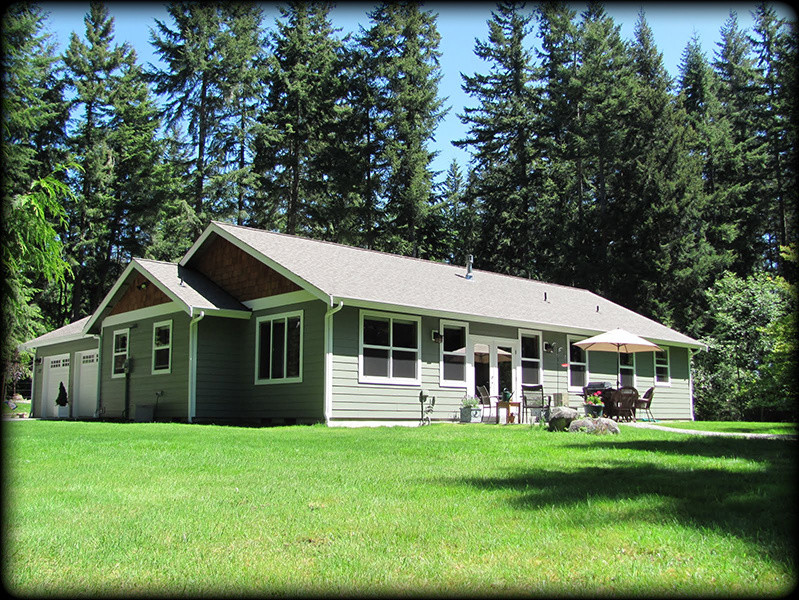 Cette photo montre une façade de maison verte craftsman de taille moyenne et de plain-pied avec un revêtement mixte et un toit à deux pans.