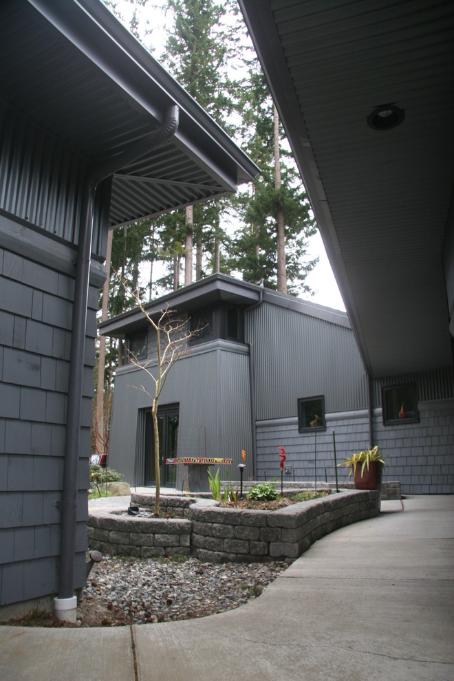 Пример оригинального дизайна: двухэтажный, серый дом среднего размера в современном стиле с комбинированной облицовкой и полувальмовой крышей