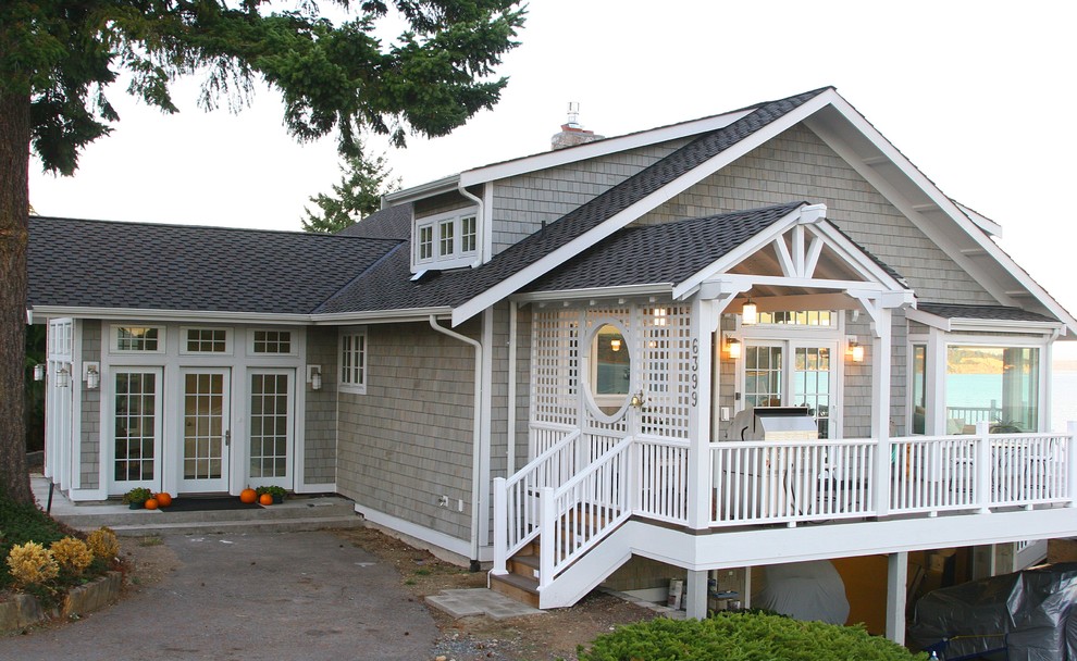 Foto della facciata di una casa beige stile marinaro a due piani di medie dimensioni con rivestimento in legno e tetto a capanna