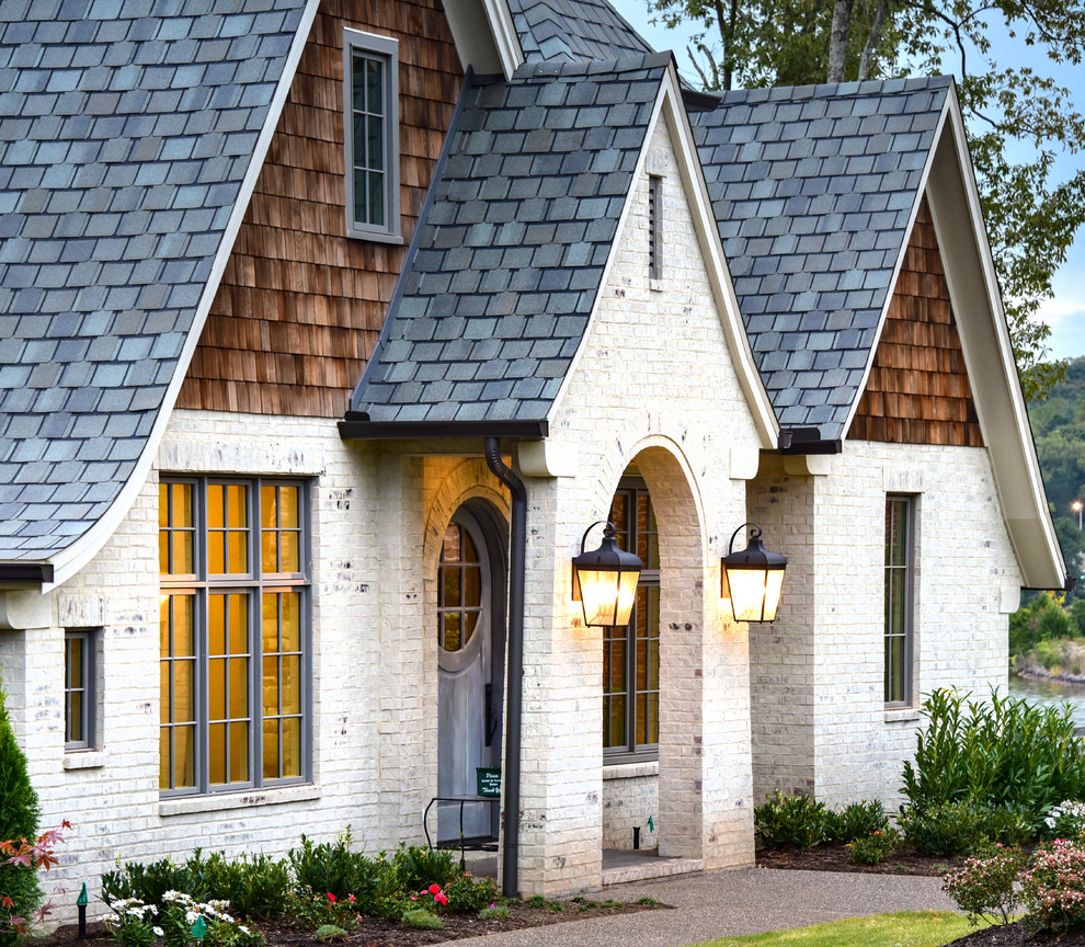 Dreistöckiges Stilmix Einfamilienhaus mit Faserzement-Fassade, weißer Fassadenfarbe, Satteldach und Schindeldach in Sonstige