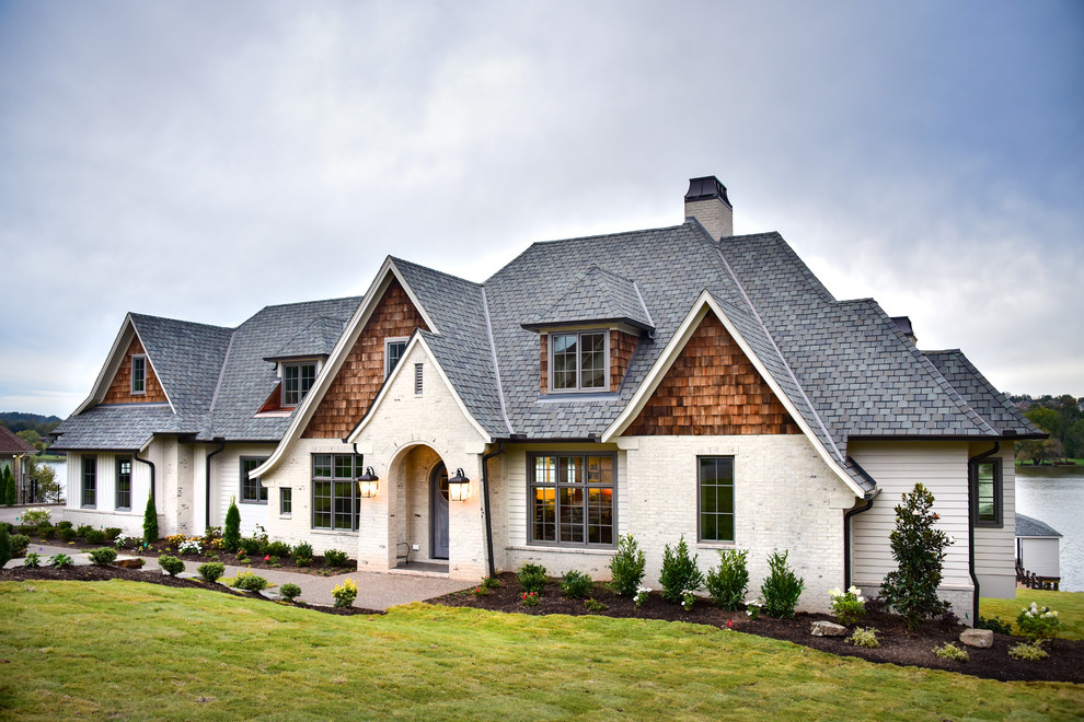 Example of an eclectic white three-story concrete fiberboard exterior home design in Other with a shingle roof