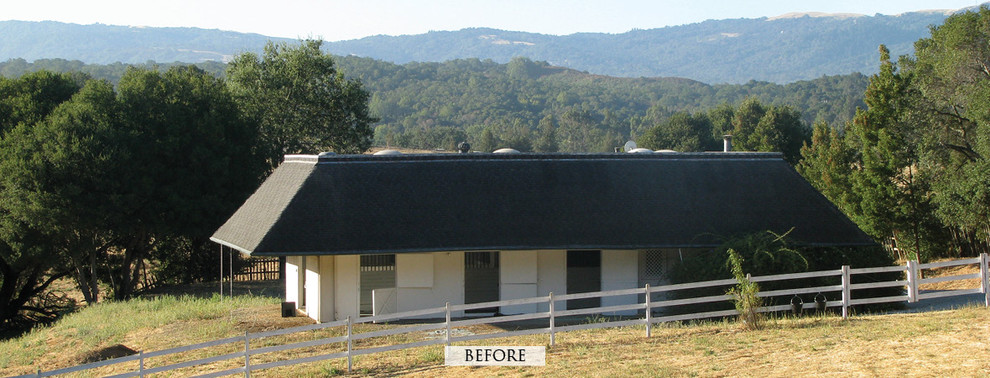 Immagine della facciata di una casa piccola bianca country a due piani con rivestimento in legno