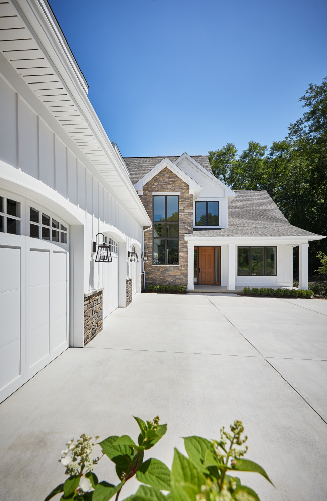 Réalisation d'une façade de maison blanche champêtre en planches et couvre-joints à deux étages et plus avec un revêtement mixte, un toit à deux pans, un toit en shingle et un toit noir.