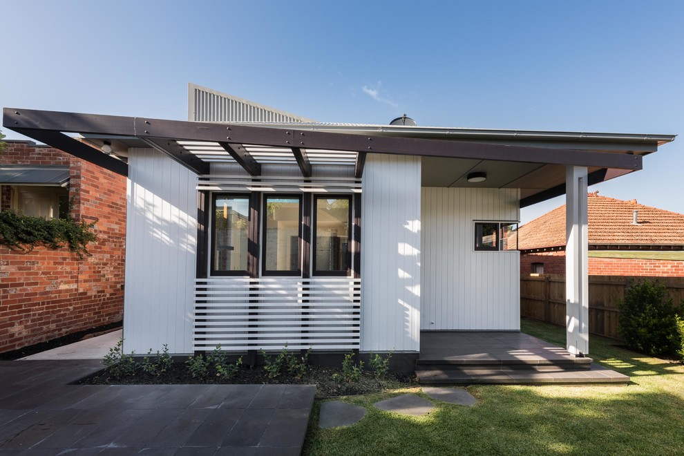 This is an example of a white contemporary bungalow detached house in Melbourne with a flat roof.
