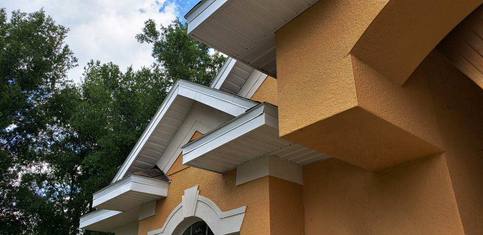 Cette photo montre une façade de maison métallique et orange à un étage avec un toit à deux pans et un toit en shingle.