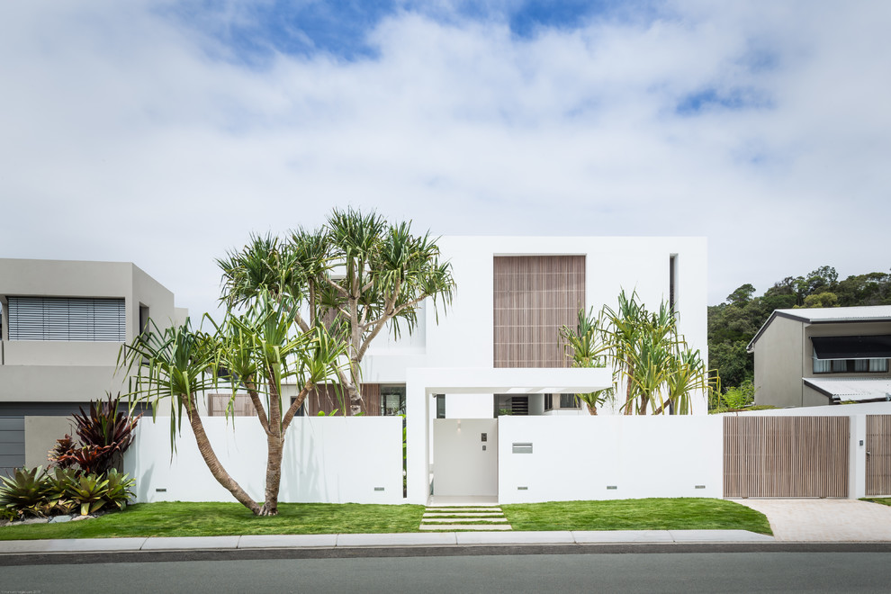 Diseño de fachada blanca moderna grande de tres plantas con tejado plano y revestimiento de hormigón